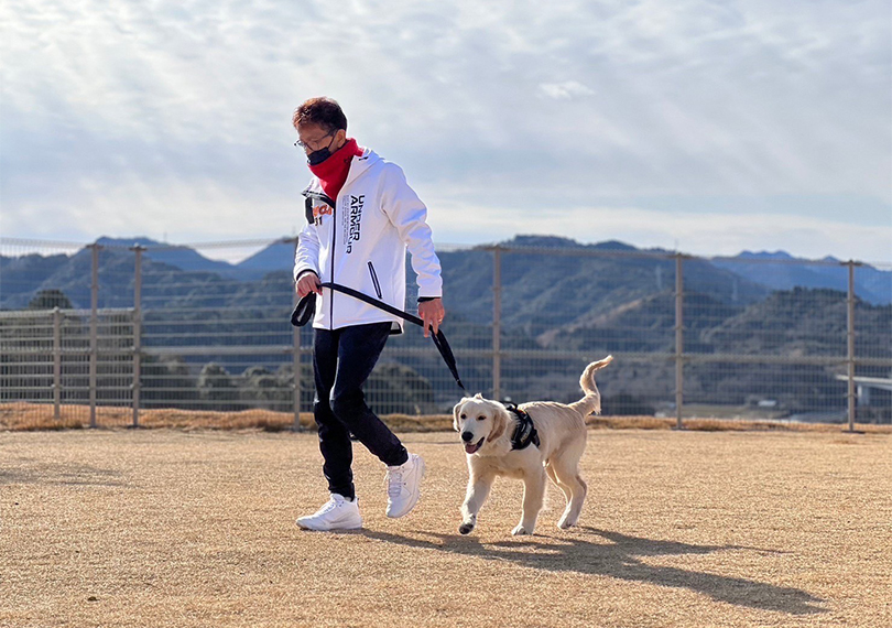 ドッグランを走る犬と飼い主